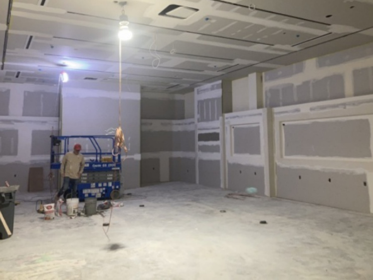Commercial buildout in progress with drywall finishing and interior construction work underway