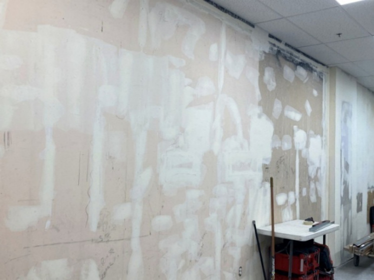 Drywall repair and finish prep during retail buildout