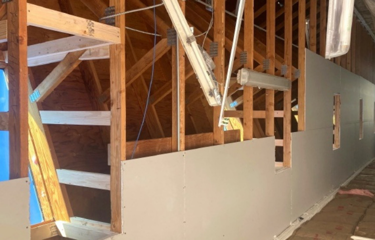 Skylight framing and drywall in progress inside outbuilding