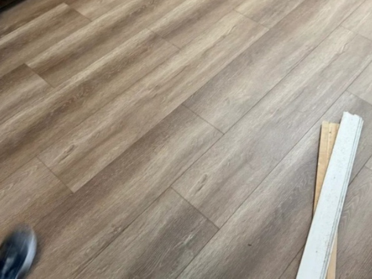 Flooring installation in progress with wood-look planks being laid