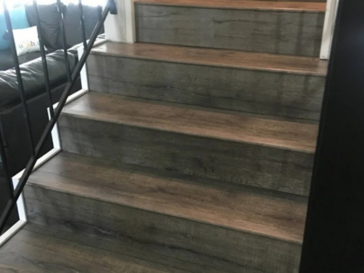 Stair flooring detail with wood-look treads and gray risers