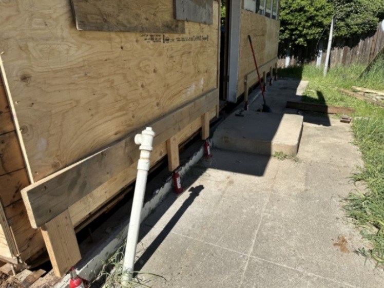 Framing and sheathing repair underway along the exterior wall